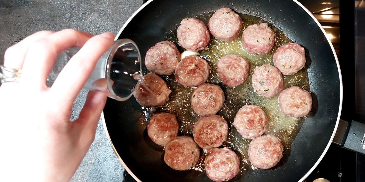 Sfumare polpette al sugo con vino bianco e completare cottura