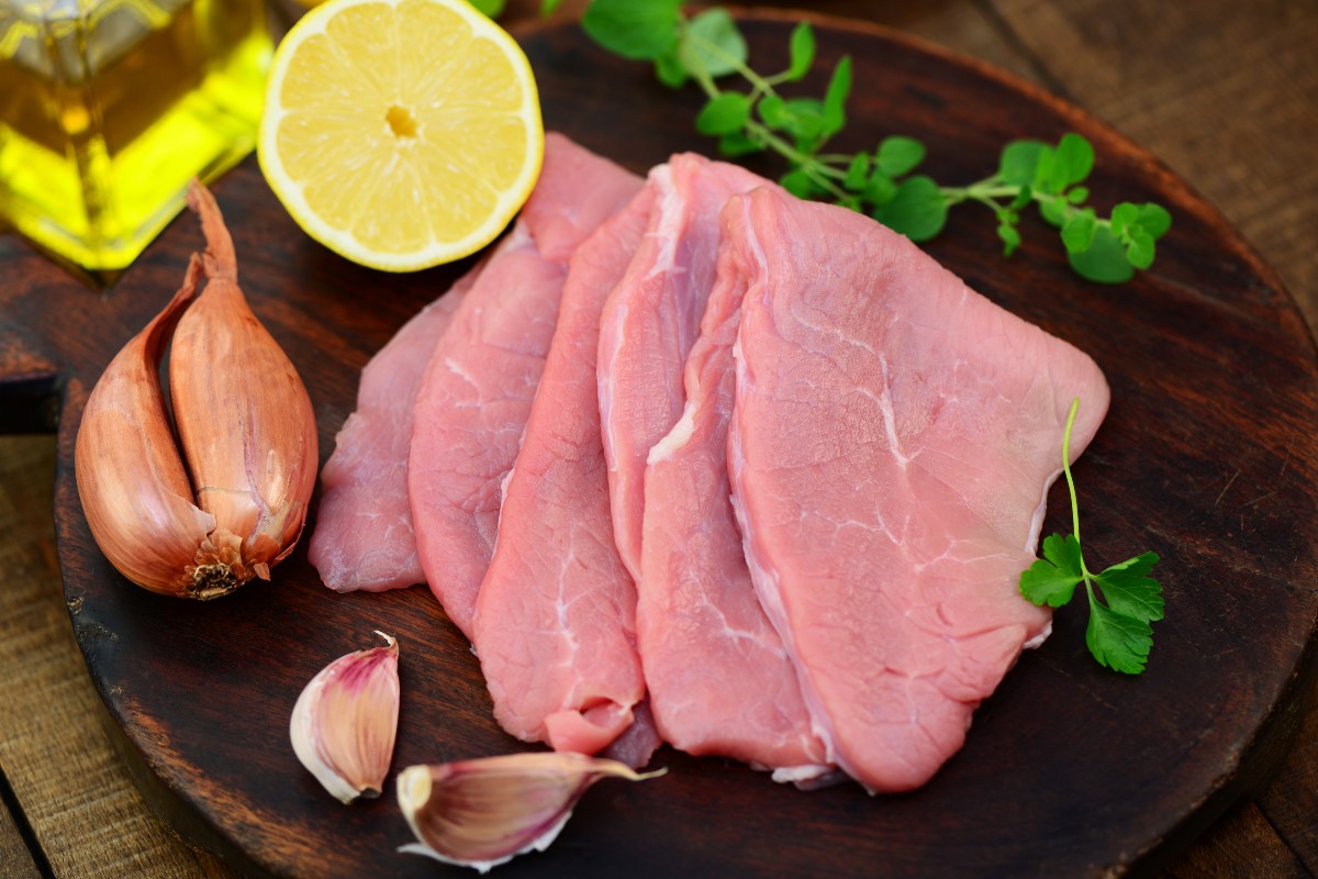 Fettine di carne di vitello tipo scaloppine su tagliere di legno