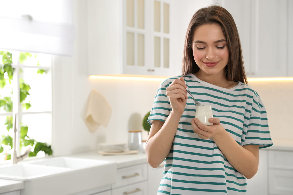 Donna a dieta che mangia lo yogurt