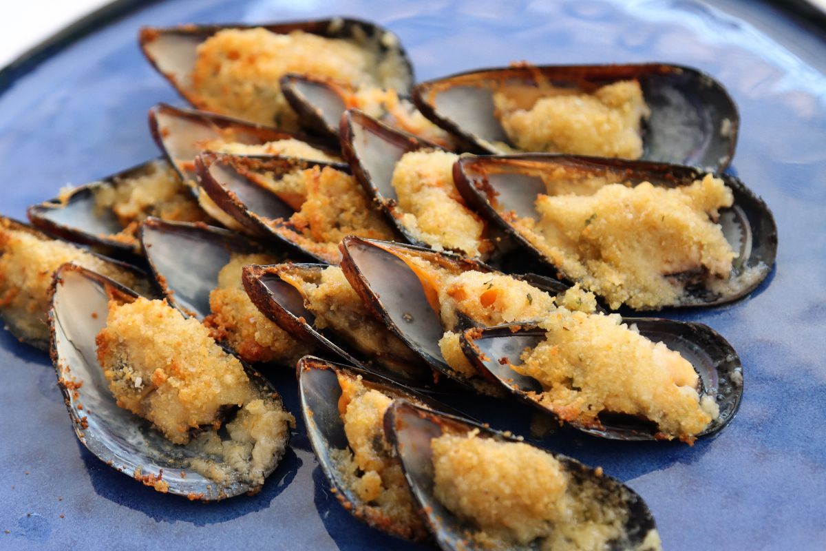 Piatto di cozze ripiene di pane e formaggio e poi fritte