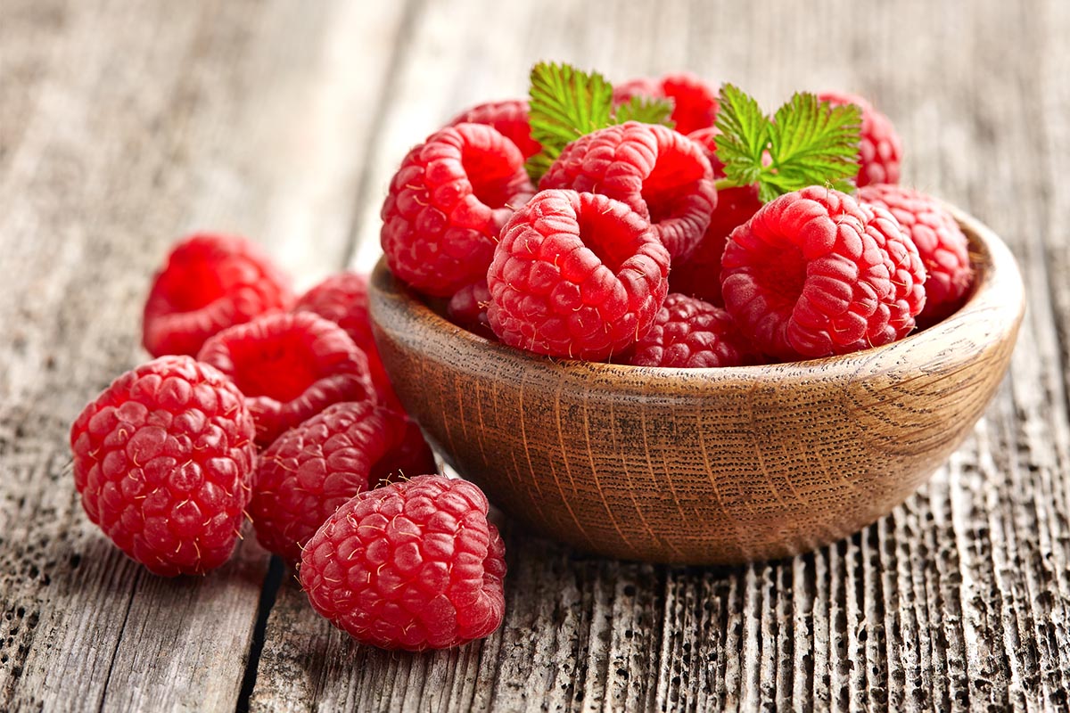 Wooden bowl with raspberries