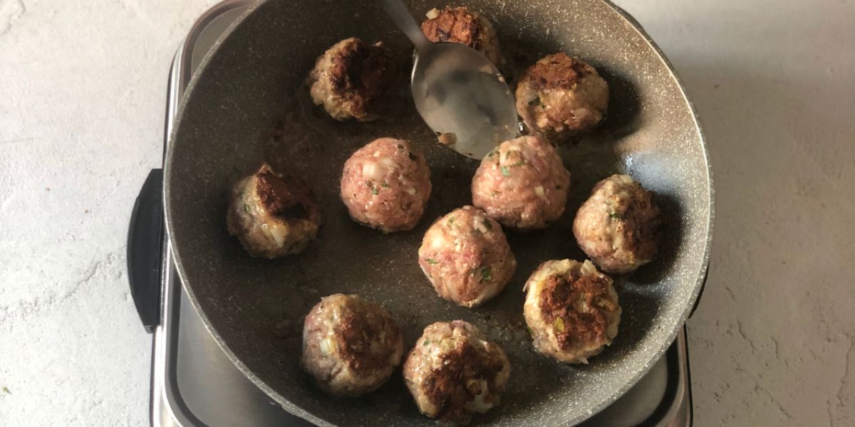 Girare polpette in padella con cucchiaio