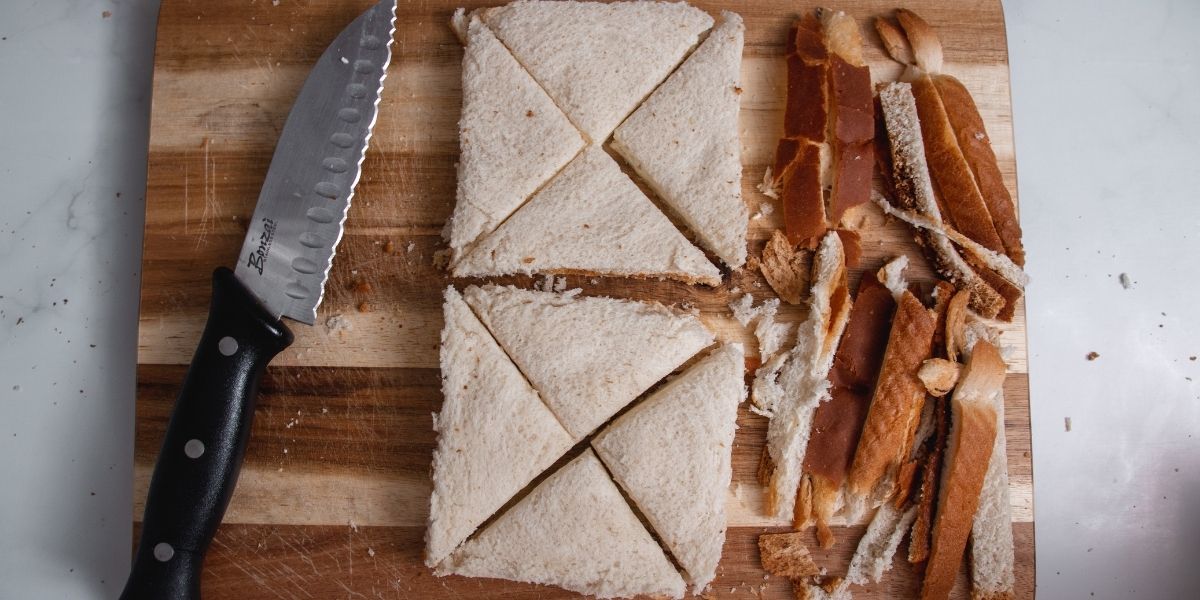 Tagliare le croste e dividere in triangoli i panini