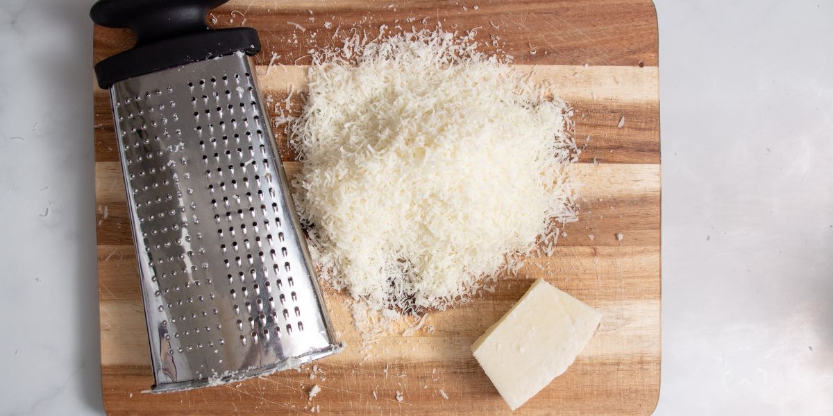 Grate cheese for cacio e pepe