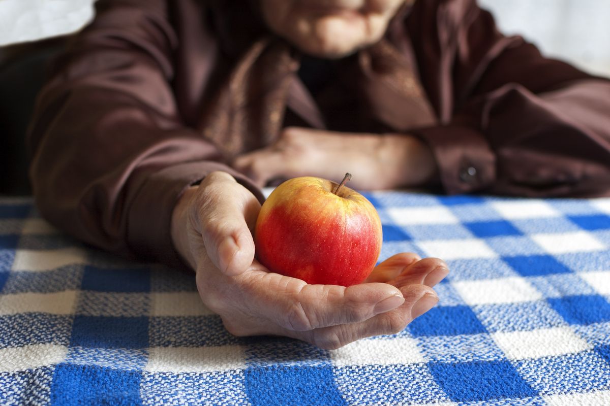 Donna anziana con una mela