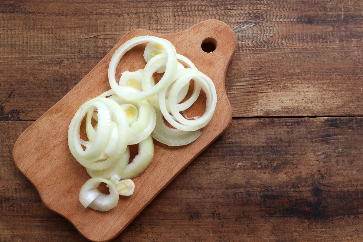 Cut onion rings on wooden cutting board