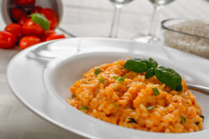 Piatto con risotto al pomodoro decorato con basilico