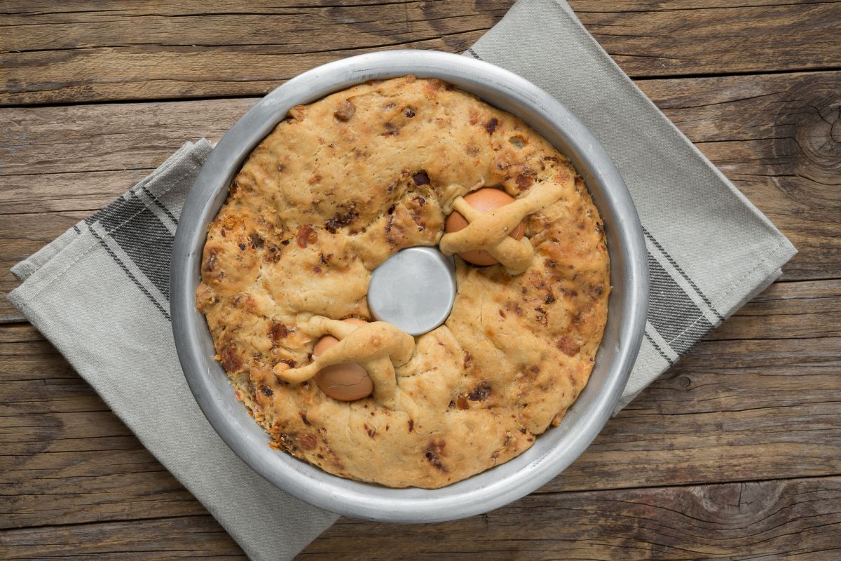 Casatiello decorated with two eggs seen from above in an aluminum pan