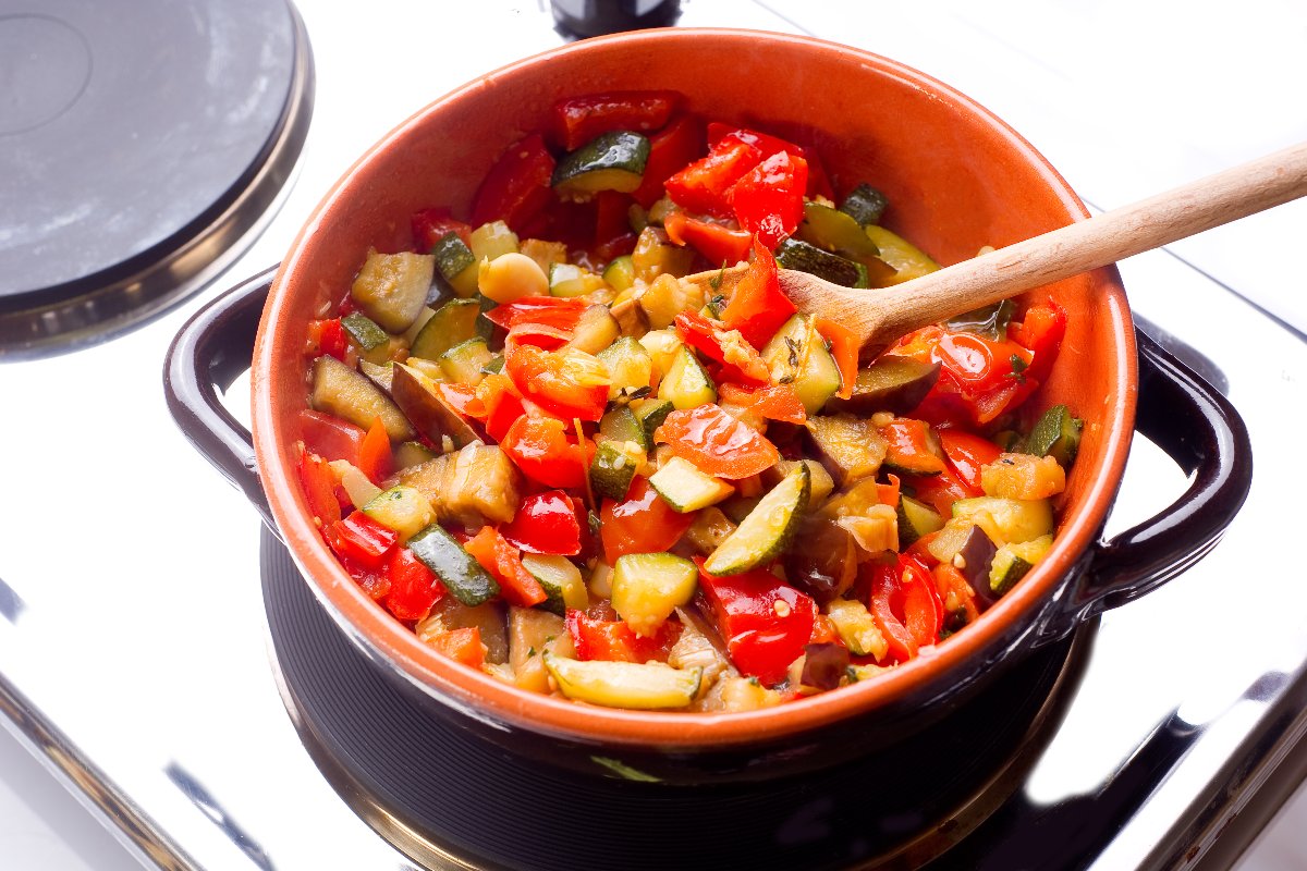 Peperoni, zucchine e melanzane cotti in un tegame di coccio