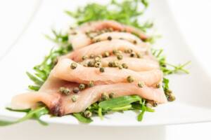 Piatto con rucola, carpaccio di pesce spada e pepe verde