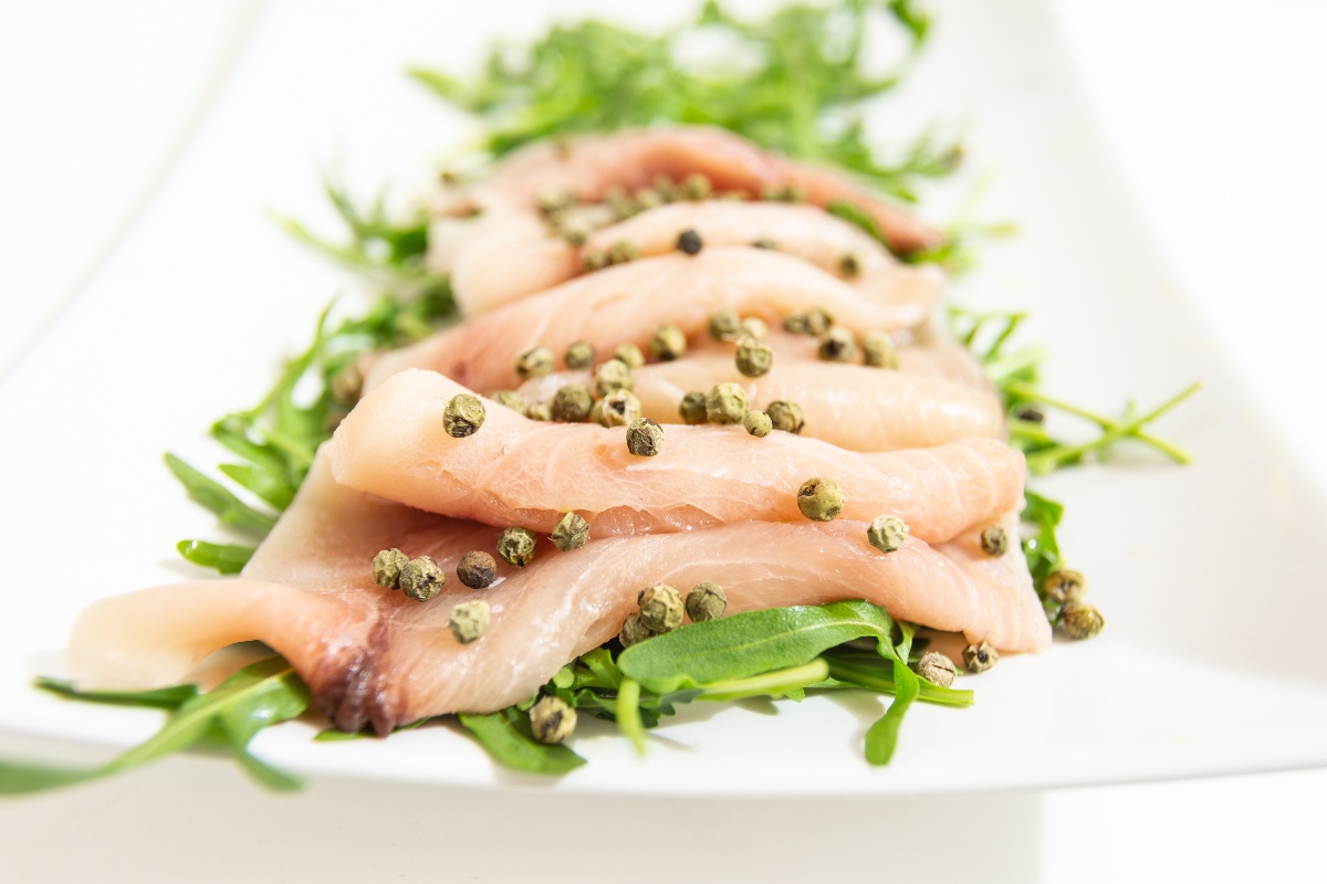Piatto con rucola, carpaccio di pesce spada e pepe verde