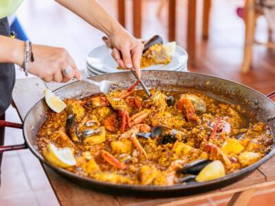 cameriere che serve la paella dalla padella