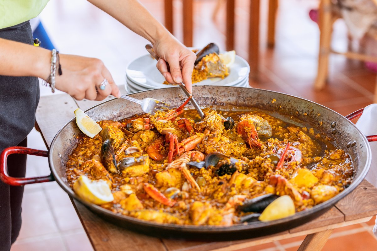 cameriere che serve la paella dalla padella