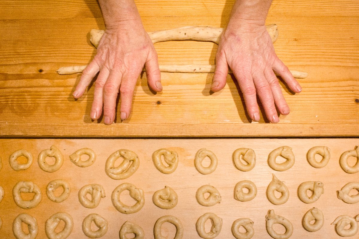 Elderly woman's hands forming a loaf of dough for taralli