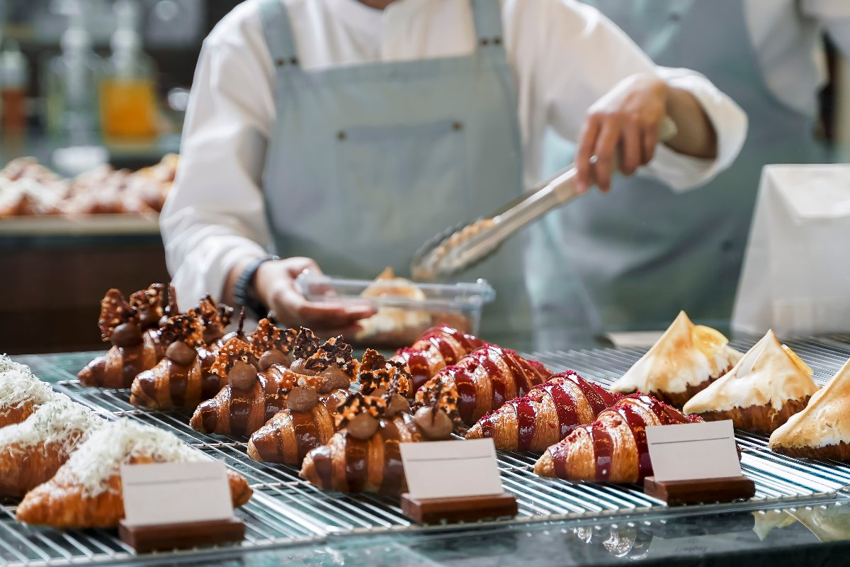 pasticcere che farcisce un croissant