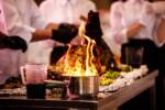 chef in cucina dietro a pentola con il fuoco