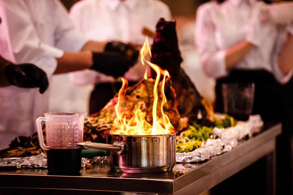 chef in cucina dietro a pentola con il fuoco