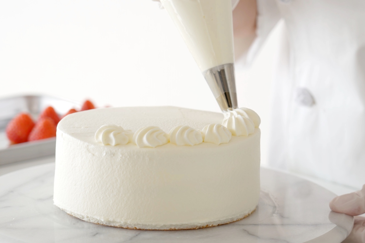 Torta decorata con panna e fragole