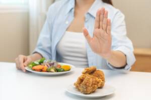 donna che rifiuta pollo fritto per la verdura