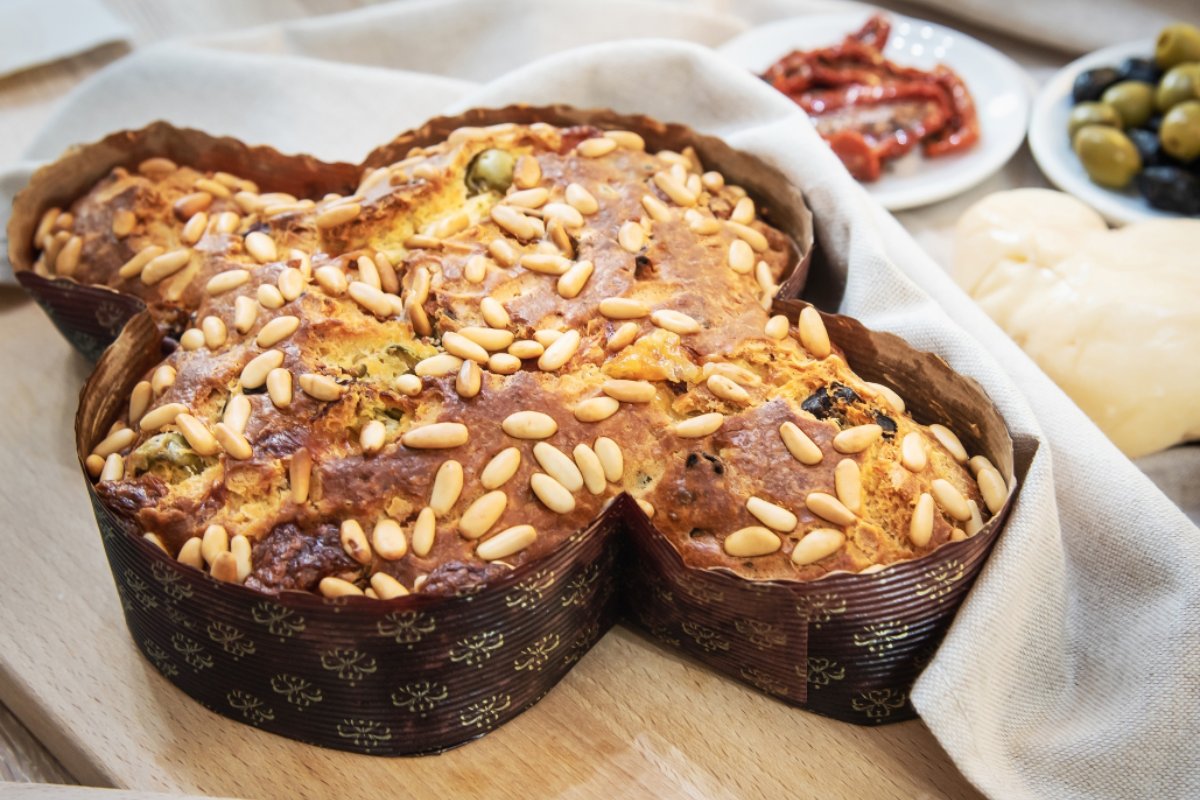 Colomba in the paper mold stuffed with savory ingredients and decorated with pine nuts