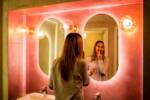 Una ragazza si sta truccando con il rossetto nel bagno di un locale