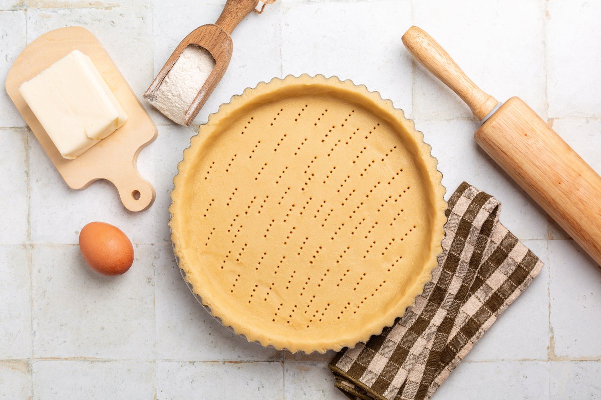 Vista dall'alto base per crostata in pasta sablée con ingredienti attorno