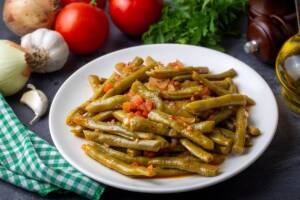 Piatto di fagiolini cotti con pomodoro, aglio e cipolla