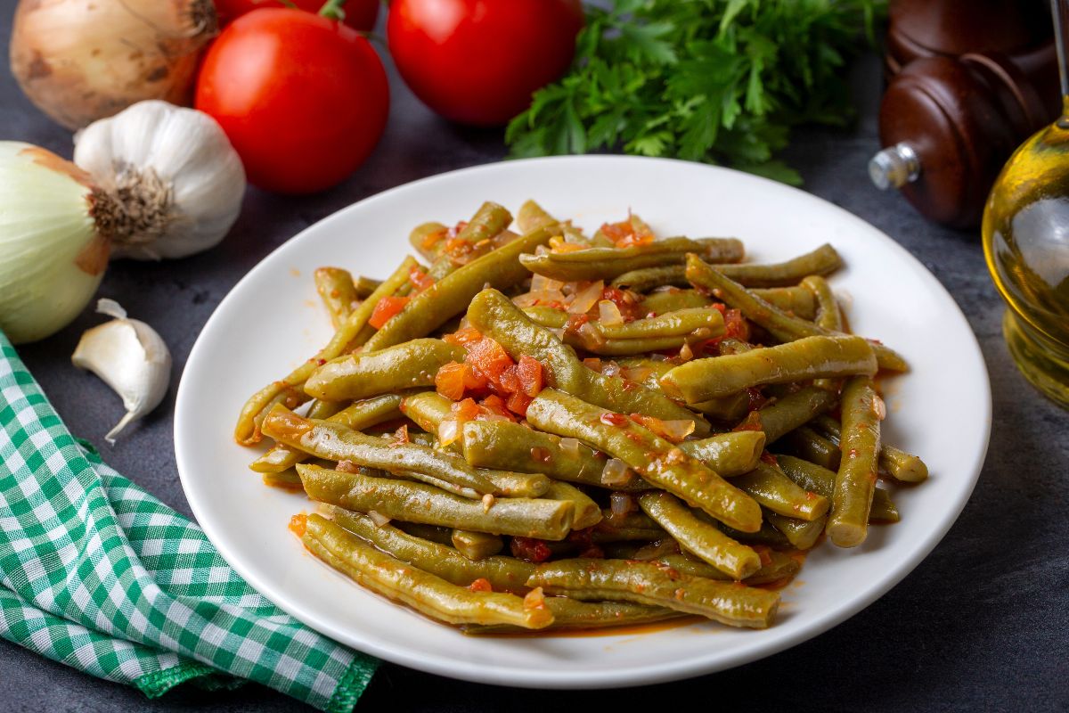 Piatto di fagiolini cotti con pomodoro, aglio e cipolla