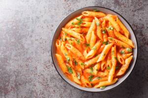 Goloso piatto di pasta alla cardinale, delizioso primo piatto cremoso condito con passata di pomodoro, panna e pecorino