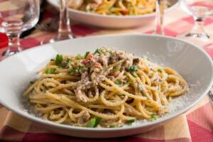 Piatto di pasta spaghetti alle acciughe con prezzemolo e formaggio