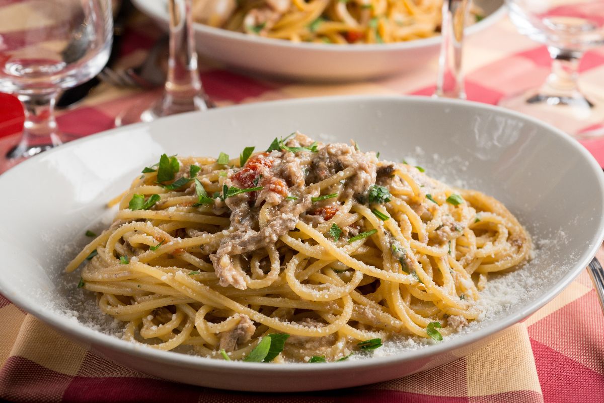 Piatto di pasta spaghetti alle acciughe con prezzemolo e formaggio