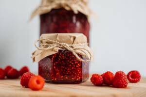 Vasetti di marmellata di lamponi con lamponi freschi vicino