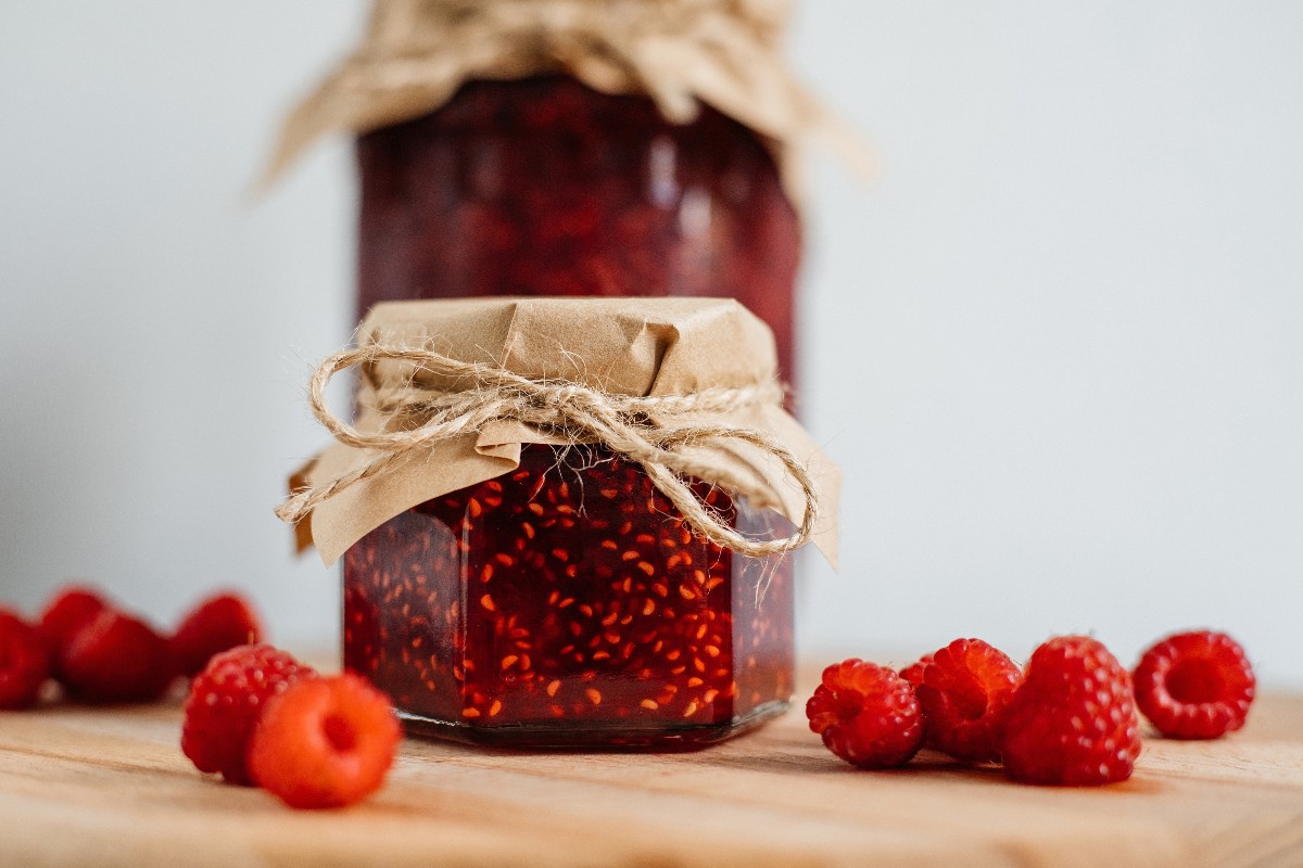 Vasetti di marmellata di lamponi con lamponi freschi vicino