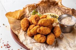 Carta forno stropicciata con cozze fritte e salsa