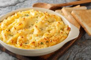 Patate lessate e schiacciate con formaggio, fagiolini e burro