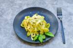 Tagliatelle al pesto: pasta condita con parmigiano e basilico fresco.