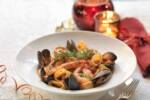 Calamarata di mare: piatto di pasta con gamberi e cozze su un tavolo natalizio.