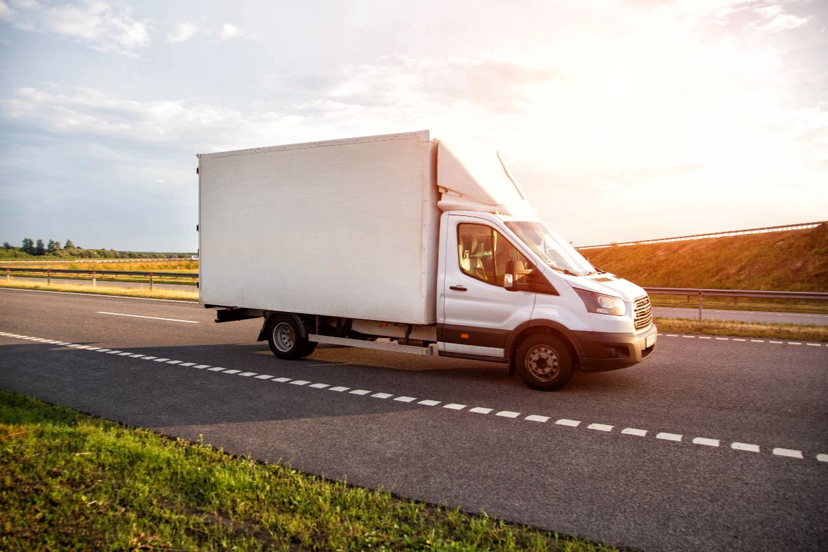 Trasporto refrigerato: un furgone bianco in movimento lungo la strada.