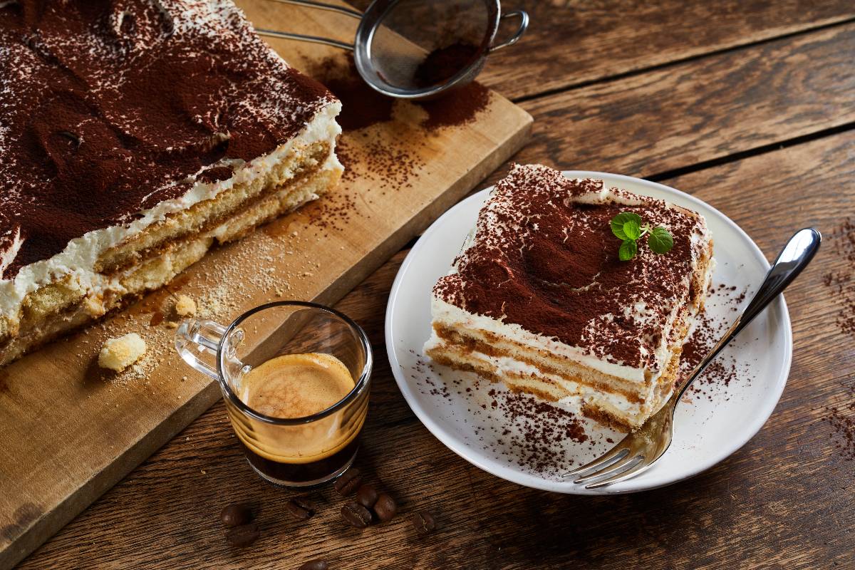 Tiramisù accanto a tazzina di caffè.