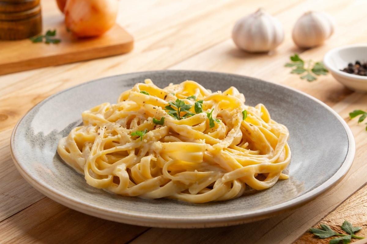 Piatto di pasta tipo fettuccine condita con formaggio grattugiato