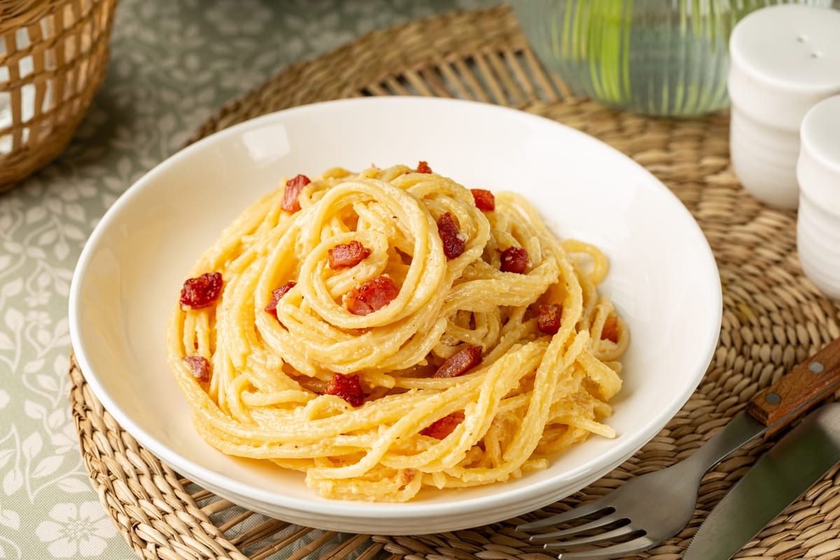 Piatto di pasta tipo spaghetti alla carbonara con peperoni