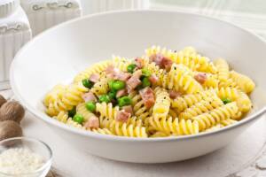 Fusilli alla carbonara con l'aggiunta di piselli.
