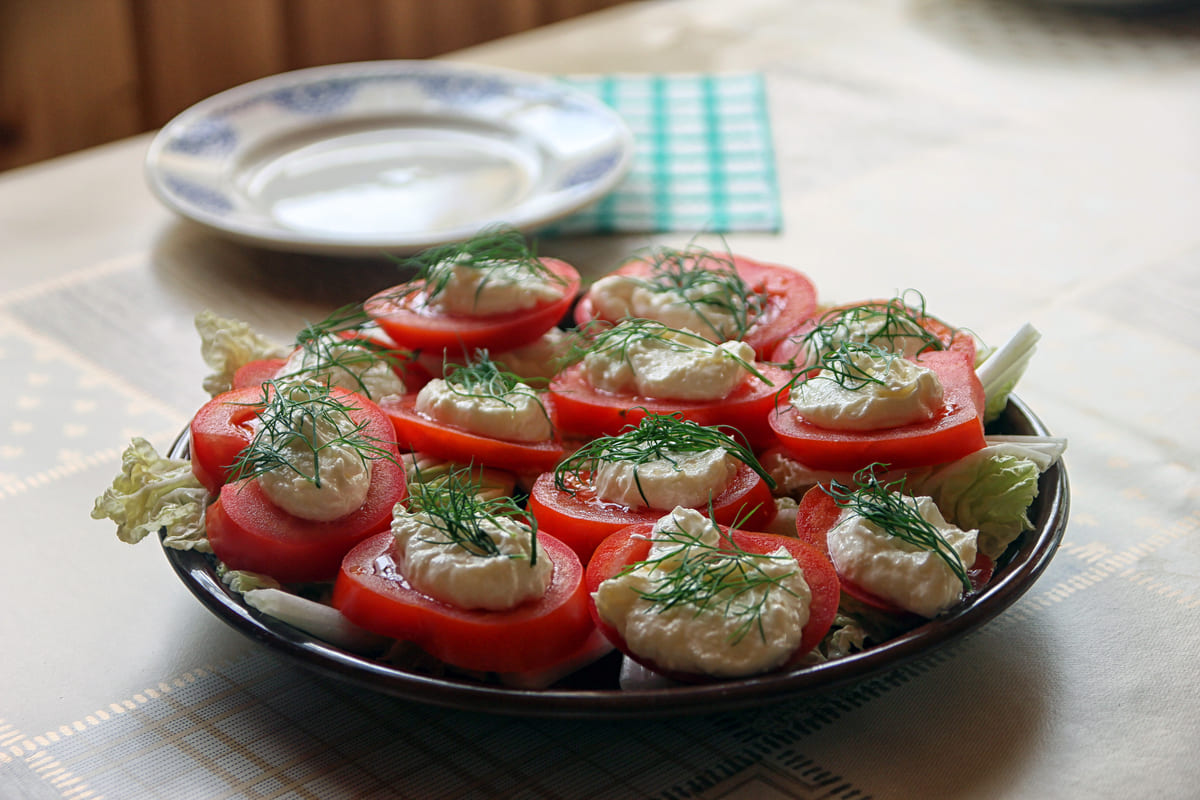 Piatto con pomodori tagliati a fette e sopra salsa tonnata